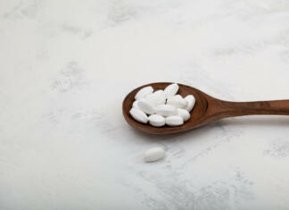 Aspartam prinaša raka? Mit ali resnica? Pills Natural sugar substitute in wooden spoon, close-up. Selective focus. Sweetener as food additive used with drinks for diabetes and weight loss. Low carb diet.