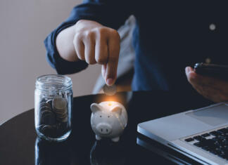 Nasveti ‘skopuške’: To so moji štirje triki za hitro varčevanje denarja Businessman hand putting money coin into piggy and saving money concept.