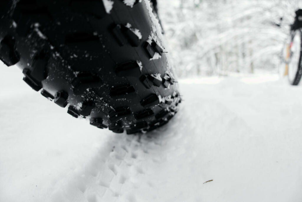 Fat bike winter tire with spikes close-up shallow depth of field.