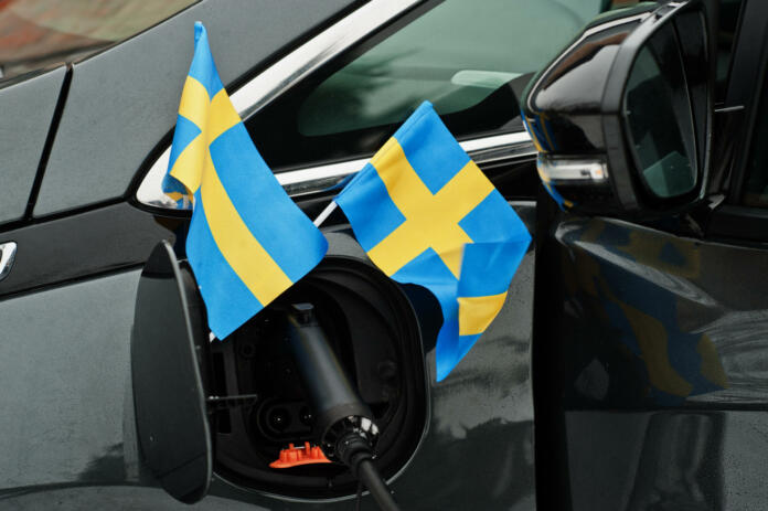 Sweden flag ecological car concept. Plugging a power supplier, charging modern automobile.