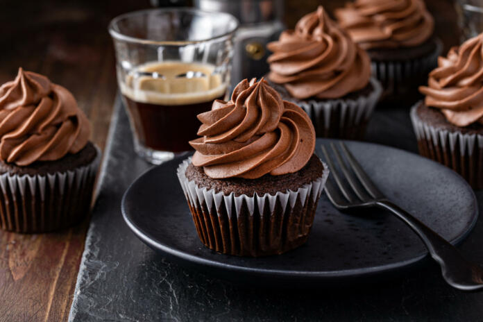 Dark chocolate irish coffee cupcakes with whipped whiskey ganache frosting and white chocolate curls served with coffee