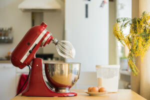 red stand mixer mixing white cream, kitchen