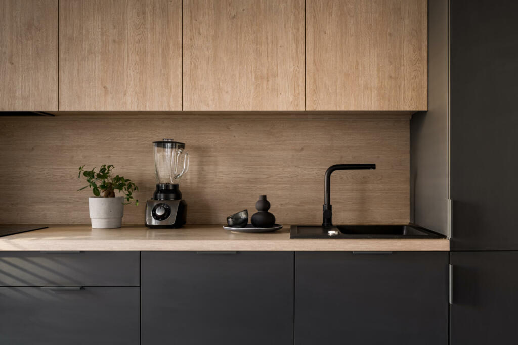 Wooden kitchen countertop with black sink and tap and decorations