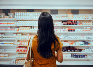 Nakupovalne navade lahko predvidijo vzrok smrti Young woman standing against shelf in pharmacy searching for medicine