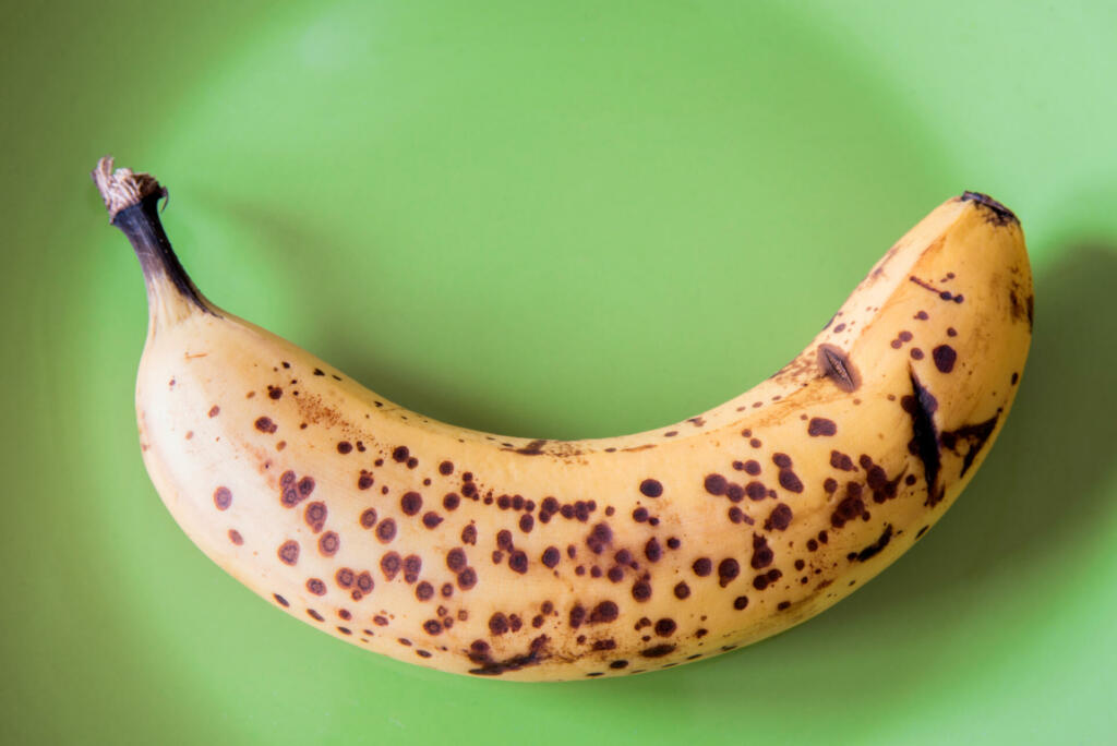 Over riped banana on green background