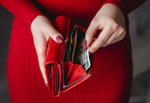Denar vam ne izpuhti čez noč: delate te “drobne” napake, ki vas na koncu drago stanejo? Red wallet in the hands of a woman in a red dress with red manicure