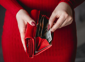 Način, kako obogateti v letu 2024!? Razkriti barva in rok nakupa denarnice, ki bo privabila denar Red wallet in the hands of a woman in a red dress with red manicure