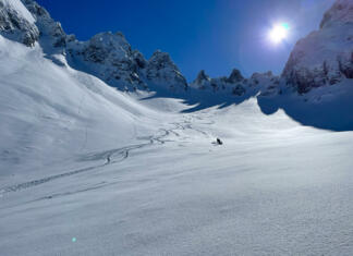 Albanija velja za najboljšo poletno destinacijo, a presenečeni boste, če se boste tja odpravili na smučanje Snowy mountain slope with fresh tracks and skier enjoying on fresh powder. Unrecognizable freeride skier enjoying skiing on fresh snow in the embrace of pristine and snow-covered Albanian mountains.