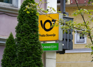 Ste slišali, kakšen regres bodo dobili poštarji? Close-up of yellow and black sign with logo of Slovenian Post outside of post office at City of Slovenian City of Bled on a cloudy summer day. Photo taken August 8th, 2023, Bled, Slovenia.