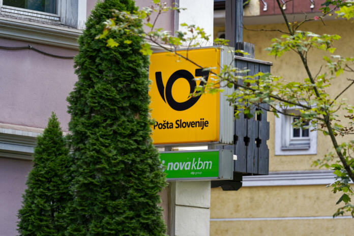 Close-up of yellow and black sign with logo of Slovenian Post outside of post office at City of Slovenian City of Bled on a cloudy summer day. Photo taken August 8th, 2023, Bled, Slovenia.
