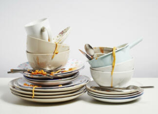 Odgovarjamo na večno vprašanje: prati na roke ali strojno? Dirty dishes pile needing washing up. Household chore concept on white background