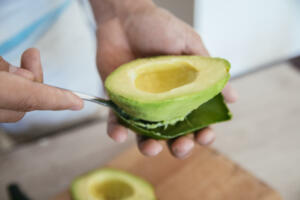 Fresh Avocado Getting Peeled With A Spoon