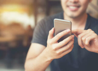 Objavljen najnovejši seznam pametnih telefonov, ki oddajajo največ in najmanj sevanja: ali uporabljate katerega od njih? Happy man using smartphone at modern coffee shop, he chatting Online Messaging on mobile phone. copy space