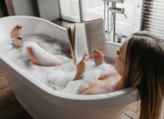 Ta predmet bi morali imeti v vseh prostorih: Preverite, zakaj Relaxation and spa day. Carefree woman lying in foamy bath, reading book and enjoying interesting story in relaxing atmosphere in bathtub at home