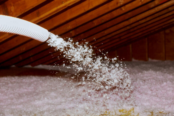 Spraying Blown Fiberglass Insulation for roof technician spraying foam insulation using plural component gun