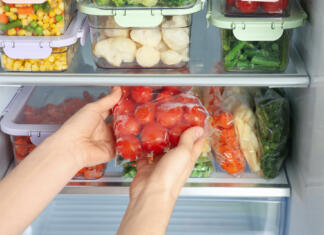 To je najbolj strupena stvar, ki jo imate v hladilniku! Woman taking plastic bag with frozen tomatoes from refrigerator, closeup