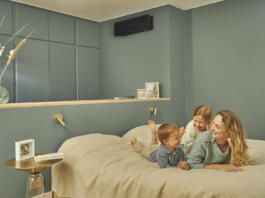 Mati z dvema otrokoma na postelji in Daikin klima na steni