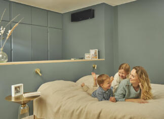 Daikin klima je ustvarjena, da vas navduši Mati z dvema otrokoma na postelji in Daikin klima na steni