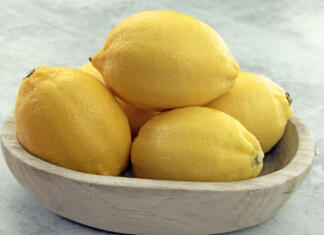 Zakaj je dobro pred spanjem poleg postelje postaviti narezano limono? Close up of bright yellow lemons in a natural wooden bowl