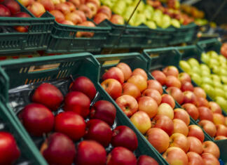 To sta sadje in zelenjava, ki vsebujeta največ pesticidov! Poročila razkriva od kod prihajata Crates of fresh fruit such as apples are for sale in the store. Buying vegetables and fruits at the market.