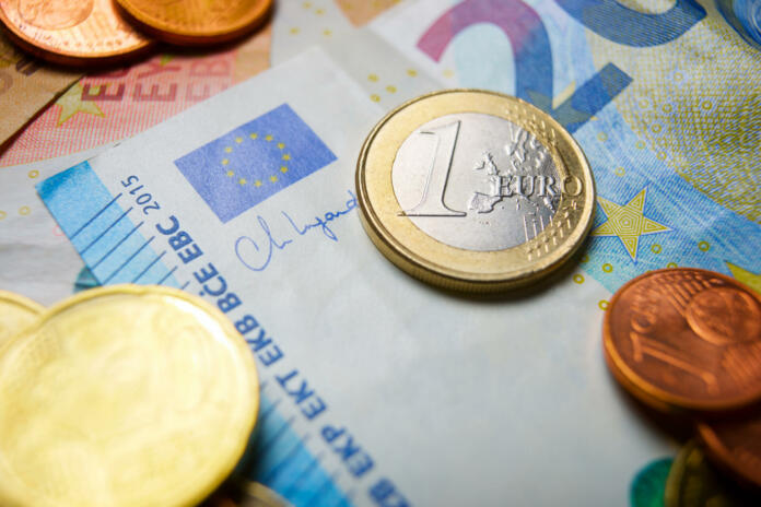 European Union banknotes and coins stacked on a table