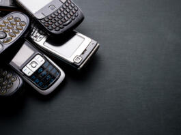 Old and obsoleted cellphones on a black background.