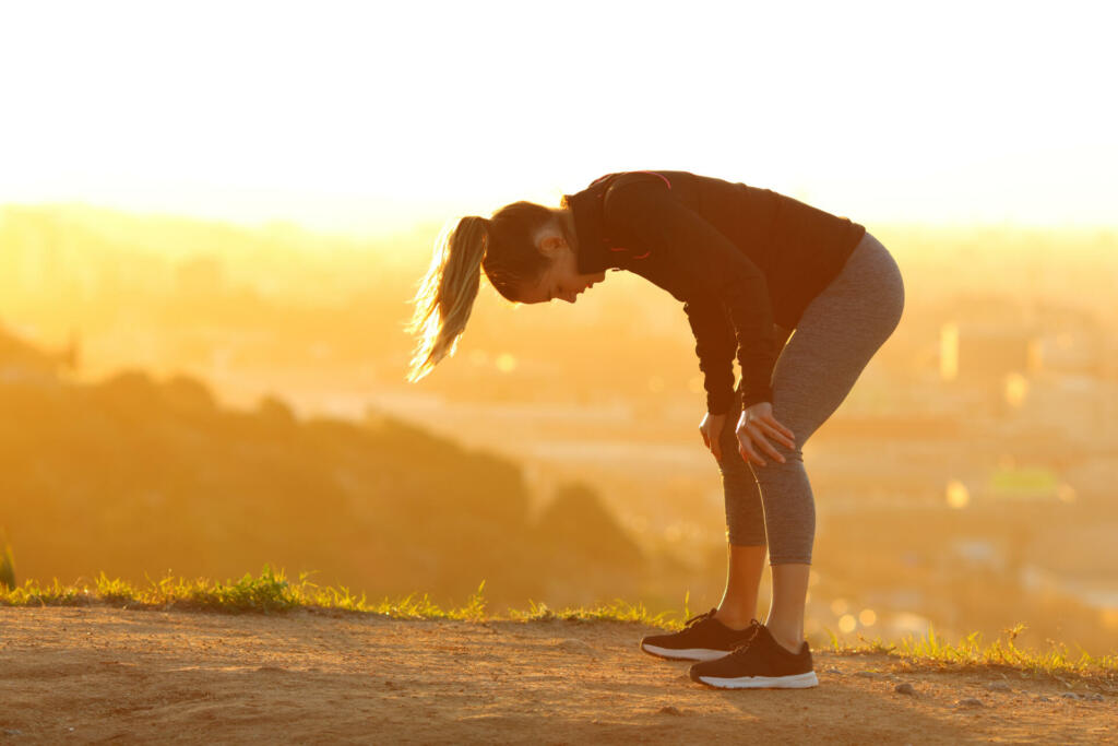 Tired runner resting after exercise in city outskirts