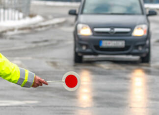 Če vas ustavi prometna policija, na to vprašanje vedno odgovorite z ‘ne’! To je razlog zakaj … Traffic policeman stops the car. Hand of cop with stop sign.