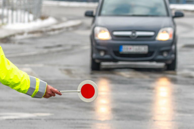 Traffic policeman stops the car. Hand of cop with stop sign.