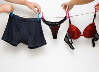 Ali tudi vi narobe perete spodnjice? Zdravnica razkrila pravi način Man's and woman's hands together hanging clean black and red undergarment. Underwear drying on laundry rope at white wall. Dry cleaning. Regular washing. Couple's daily routine. Relationships concept.