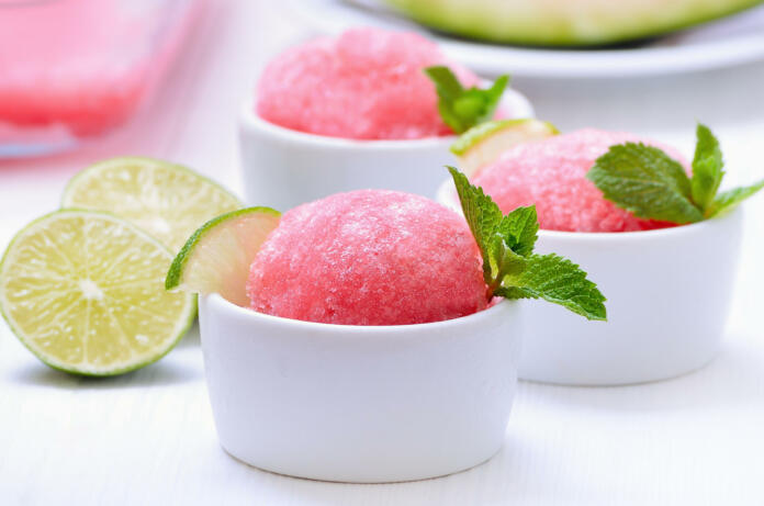 Watermelon sorbet decorated with mint in white bowl