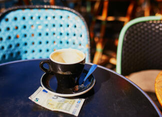 Se odpravljate na dopust na Hrvaško? Država je rekorderka EU po rasti cen kave Empty cup of black coffee and 5 euro bank note on a table of outdoor cafe in Paris, France