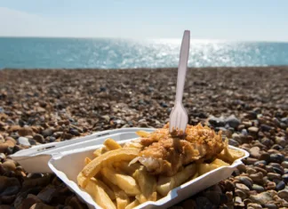 Če to hrano jeste na plaži, lahko doživite možgansko kap! Delicious fish and Chips take away meal enjoyed on the beach