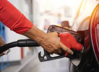 Preverite, takšne so po novem cene goriva! Refueling the car at a gas station fuel pump. Man driver hand refilling and pumping gasoline oil the car with fuel at he refuel station. Car refueling on petrol station. Fuel pump at station
