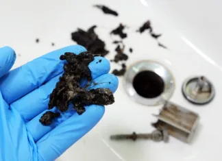 Vodovodarji: Nikoli ne zlijte teh 4 stvari v odtok! Plumber holding mass of hair and grime from clogged sink.