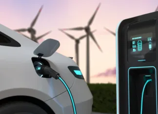 Objavljene nove subvencije za nakup električnih vozil! Electric cars Charging at the charging station and with a Wind turbine background, Electric power is an alternative fuel. 3D illustration