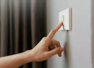 Strokovnjaki svarijo! »Ko so priključeni na elektriko, te naprave najbolj porabljajo energijo; tudi če niso prižgane« Close up of Female finger is turn off on lighting switch at home. Power, Energy, Saving Electrical, Copy space.