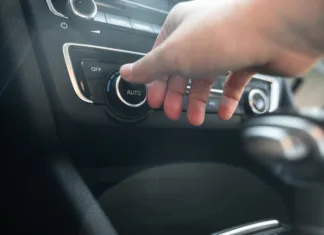 Mnogi vozniki to storijo takoj, ko sedejo v avto! A to je v Nemčiji že strogo prepovedano Close-up of hand using temperature control knob on car dashboard from driver side