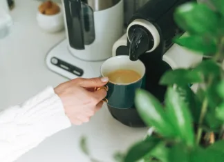 ‘Vampirske naprave’, ki jih morate izklopiti iz elektrike, ker porabijo veliko energije Crop photo of young woman pours coffee from coffee machine in kitchen at home