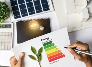 10 nasvetov za izboljšanje energetske učinkovitosti vašega doma House Energy Audit. Energy efficiency concept with level chart Tabletop energy efficiency graph with house diagram calculator Solar panels. Businessman planning to use energy.