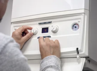 Prepoved bojlerjev! Upoštevati bo treba nove predpise in poiskati alternative Adjusting thermostat setting on domestic home heating system central heating boiler