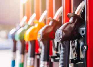 Počakajte z obiskom bencinske črpalke! To so nove cene goriv …. Diesel petrol fuel pistols nozzle refill at gas station. Fuel price crisis impact fuel cost in transport business and Travel energy consumption rise in petroleum gasoline station service production.