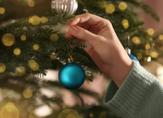 Naredite novoletne okraske za 0 evrov! Vse to imate doma, izdelava je hitra in enostavna (VIDEO) Woman decorating Christmas tree with beautiful light blue bauble, closeup