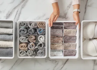 Organizacijska načela Marie Kondo: Kako vzpostaviti red v vašem domu in življenju Woman hands placing wardrobe drawer organizers with full of folded underwears. Sock drawer with folded socks. Perfect and neatly setting of clothes. Linen drawer organization solution. Perfectionist.