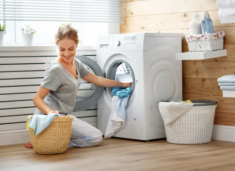 a Happy housewife woman in laundry room with washing machine