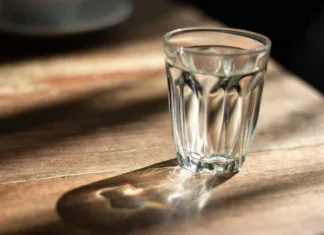 Vsak večer pred spanjem postavite kozarec vode pod posteljo: Neverjetno, kakšna čarovnija vas pričaka zjutraj water in glass on wooden table with shadow ,morning sunshine