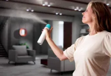 Kako se znebiti vonja po starem? Woman Using Air Spray In Living Room