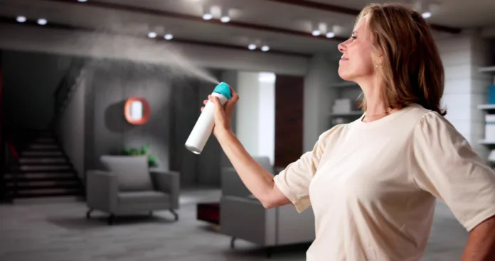 Woman Using Air Spray In Living Room