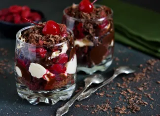 Sladice v kozarčkih: vse, kar morate vedeti o tej kulinarični poslastici Dessert black forest in a glass. Chocolate dessert with creamy cream, cherry and chocolate on a concrete background. The Schwardzwald.