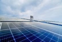 Sončne celice so slaba ideja! engineer man inspects construction of solar cell panel or photovoltaic cell by electronic device. Industrial Renewable energy of green power. factory worker working on tower roof.